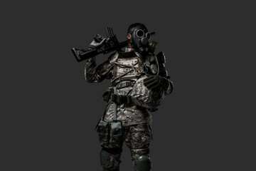 Obraz na płótnie Canvas Studio shot of black military man holding rifle on his shoulder isolated on grey background.
