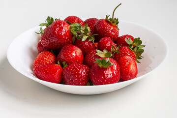 Fresh ripe strawberries in a white plate. Close-up. Harvest strawberries. Dessert.