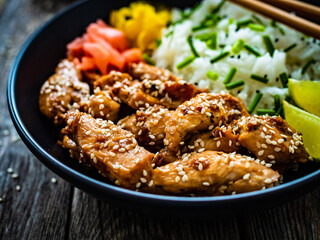 Teriyaki chicken nuggets with rice and vegetables on wooden table
