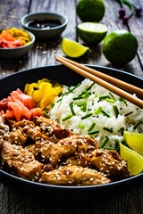 Teriyaki chicken nuggets with rice and vegetables on wooden table
