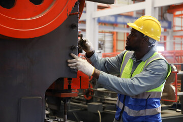 A worker working or operating in metal factory while machining in production industry