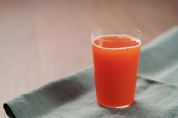 Organic grapefruit juice in tumbler glass on linen napkin