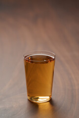 Organic apple cider in tumbler glass on wood table