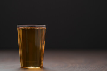 Organic apple cider in tumbler glass on wood table