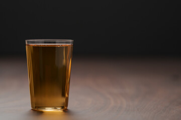Organic apple cider in tumbler glass on wood table