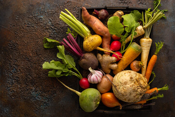 Fresh root vegetables in wooden box on textured background. Autumn harvest. Concept healthy food. - obrazy, fototapety, plakaty