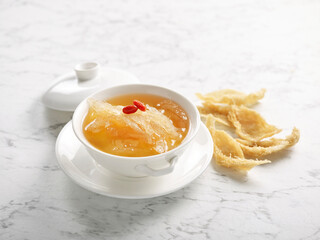 Double-boiled Supreme Bird’s Nest with Superior Broth served in a bowl side view on grey marble background