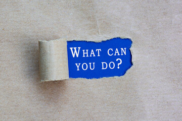 What can you do text on torn hole in the sheet of brown paper on blue background