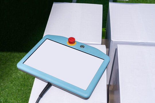 Teach pendant device for programming robot with robotic arm. Smart factory 