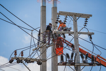 Electricians is repairing high voltage wires on electric power pole
