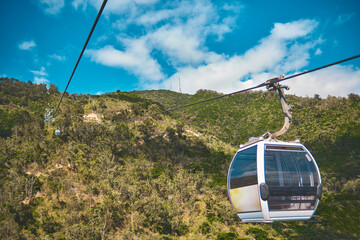 Modular cabins cable car against the bright sky, clouds ans mountains. Cableway - one of the...