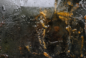 Texture, background, top view of a black metal tray smeared in fat, oil, pieces of old meat, after cooking a dish. Food photography, abstraction, top view.