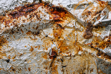 Background, texture, top view of dirty, greased, sunflower oil after cooking a meat dish, foil. Food photography.