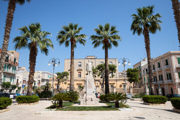 Fototapeta na wymiar Monopoli, Italy, Apulia - May 23, 2022: view of the city square with a statue 