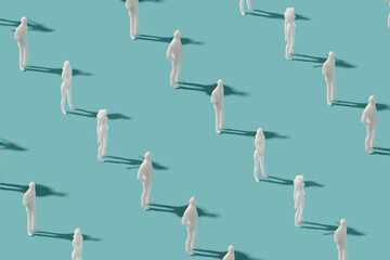 Plastic human figurines arranged on a pastel blue background. Futuristic society minimal pattern