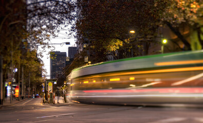 Obraz premium Long exposure of Melbourne tram at the intersection of Collins and Spring St at dusk