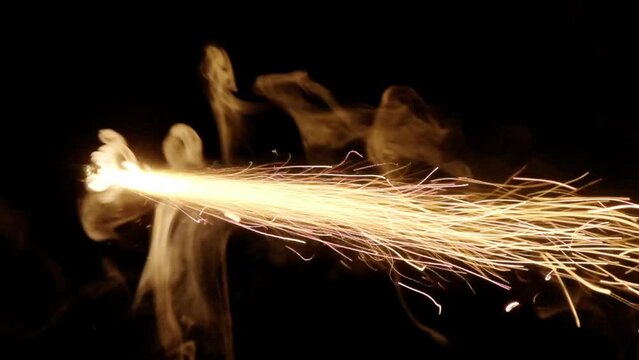 A professional fuse used to ignite bengal fires or bombs, lit with a lighter, burning in slow motion in the darkness. Ending part.
