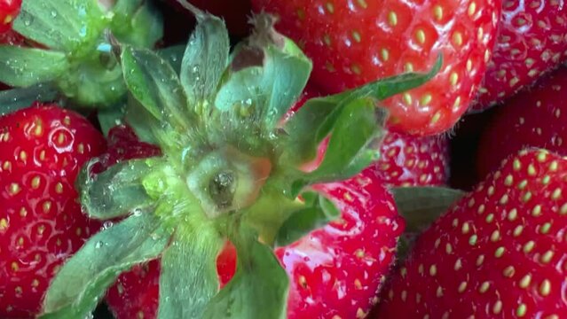 Slow motion of Background of Strawberries of Harvest summer fruit of farm. macro close-up of the summer harvest of juicy ripe strawberries from fruit store market. macro closeup Slow motion 1080p Full