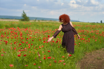 Redhead woman in a poppy field