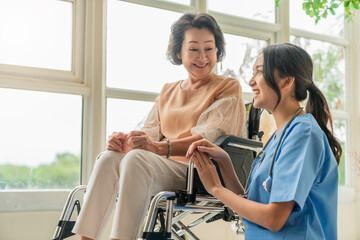 asian young caregiver caring for her elderly patient at senior daycare Handicap patient in a...