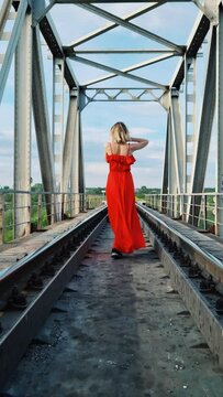 Girl in a red dress on the railroad	