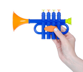 Kids toy musical instrument trumpet in hand on white background isolation © Kabardins photo