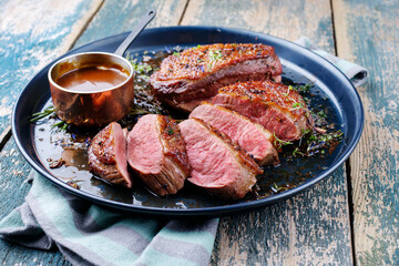 Traditional barbecue gourmet duck breast filet with skin served with potato dumplings in dark beer...