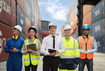 Group of engineer worker and manager standing in the shipping yard container. Truck lifting and...