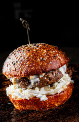 Traditional beef burger with vegetables on dark background