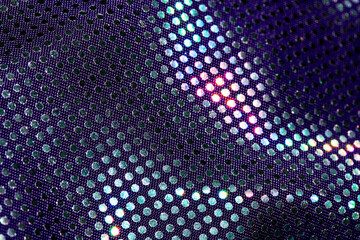 Coloured Shiny Sequins on fabric close up abstract background