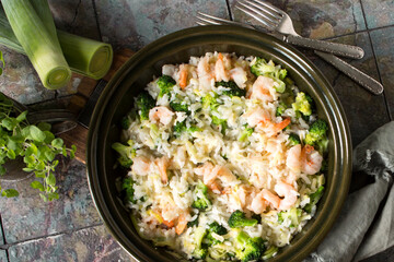 ceramic baking sheet with risotto with broccoli and shrimps on the table