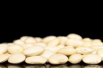Uncooked white beans, close-up, isolated on black background.