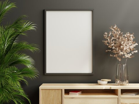 Mockup frame on wood cabinet in living room interior on empty dark wall background.