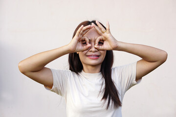 Asian woman smiling happily Raise your hand as a sign of ok.