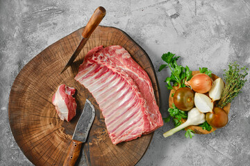 Raw fresh lamb ribs on wooden slab, top view