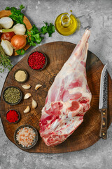 Raw whole lamb leg chump on with ingredients, top view