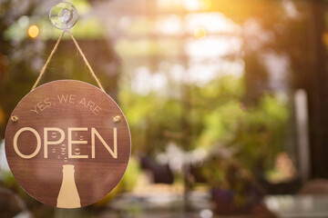 Open sign hanging front of cafe with colorful bokeh