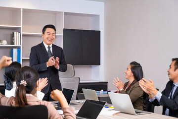 Group of business person applause and feeling happy for their success from online distance meeting in front of computer laptop. New normal for business and working.