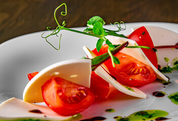 Italian Caprese salad with tomato and cheese in white plate