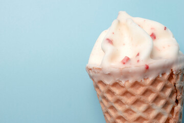 Close up of ice cream with white chocolate and strawberries pieces on green background. 