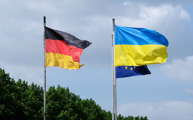 The flags of Ukraine, Germany, and the EU waving in the wind