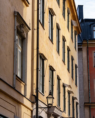 Fototapeta premium Facade of historic building with yellow stone and old street lamp. Shot in Stockholm, Sweden