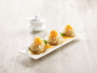 Deep-fried Yam Puff topped with Rock Melon served in a tray isolated on mat side view on grey background thailand fast food