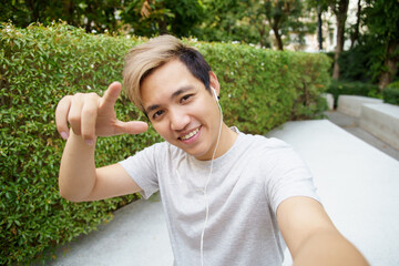 Fototapeta premium Active happy Asian sportsman taking a self portrait photography or selfie on a smartphone.