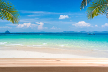 Fototapeta na wymiar Wooden table top with tropical beautiful white sand beach and blue sky background, Summer vacation concept and copy space