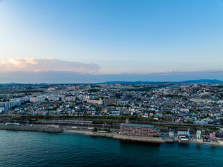 Fototapeta premium Aerial view of waterfront apartment and sprawling coastal development after sunset