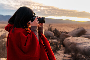portrait woman photographer taking pictures in the desert at sunset - Powered by Adobe