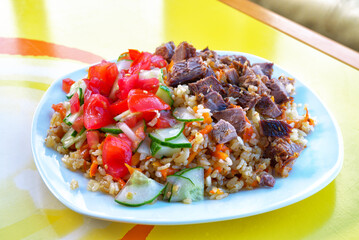 National Uzbek pilaf with meat and salad.