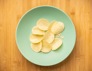 Salty grooved chips on ceramic plate. Selective focus. Shallow depth of field.