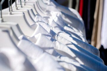 White linen shirts on hangers, selective focus
